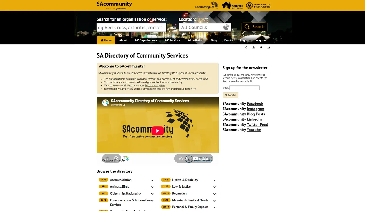 The current SAcommunity.org website: a dense, yellow-and-white community directory homepage with a top search bar, a video panel, a newsletter sign-up box and a long list of category links — a dated, text-heavy design.